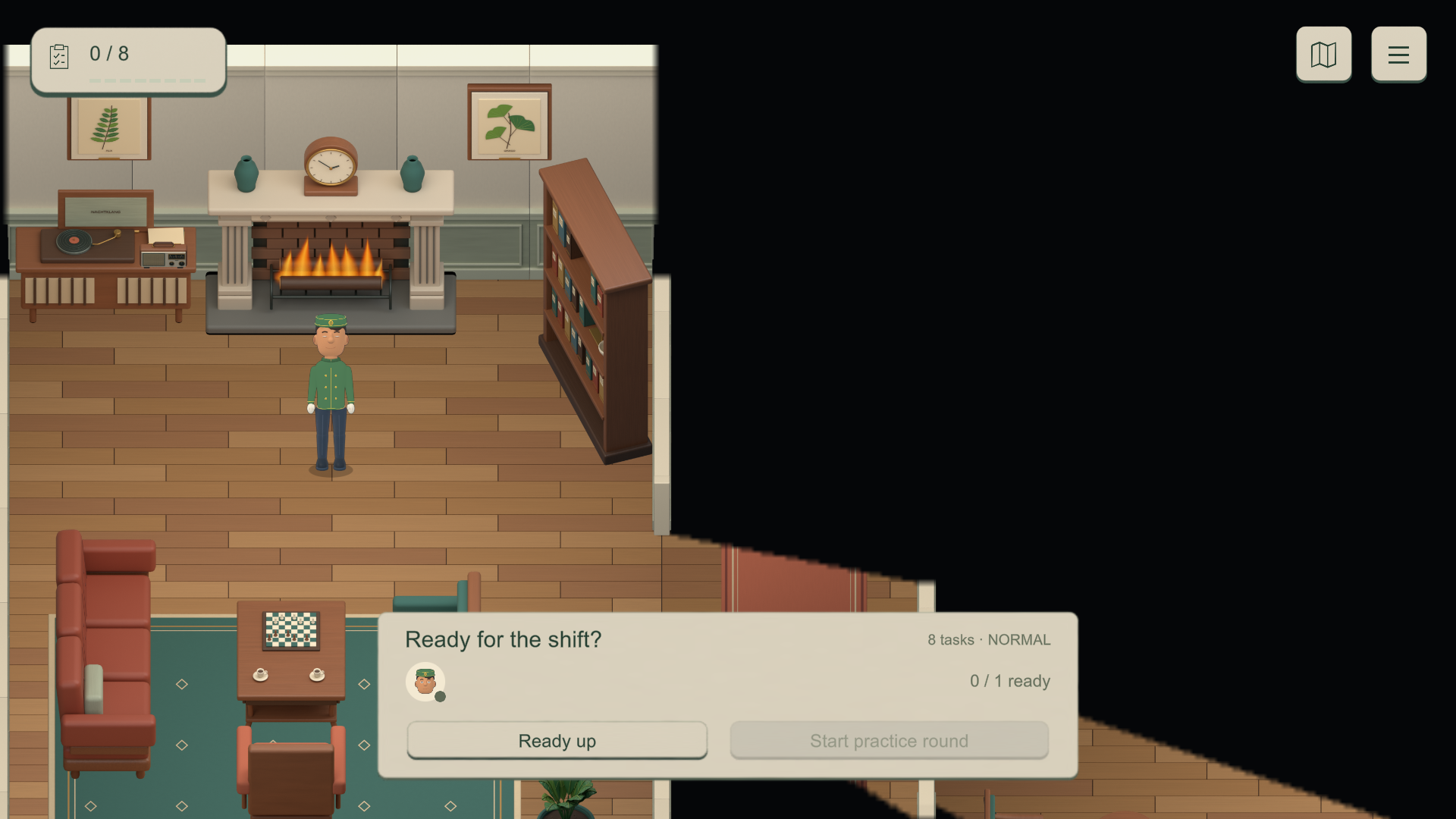 A hotel worker stands near the lounge fireplace, chairs and bookshelf